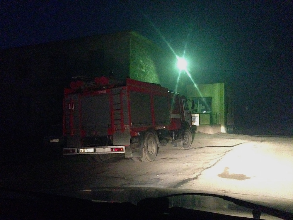 Пожарный автомобиль дежурит перед въездом на полигон